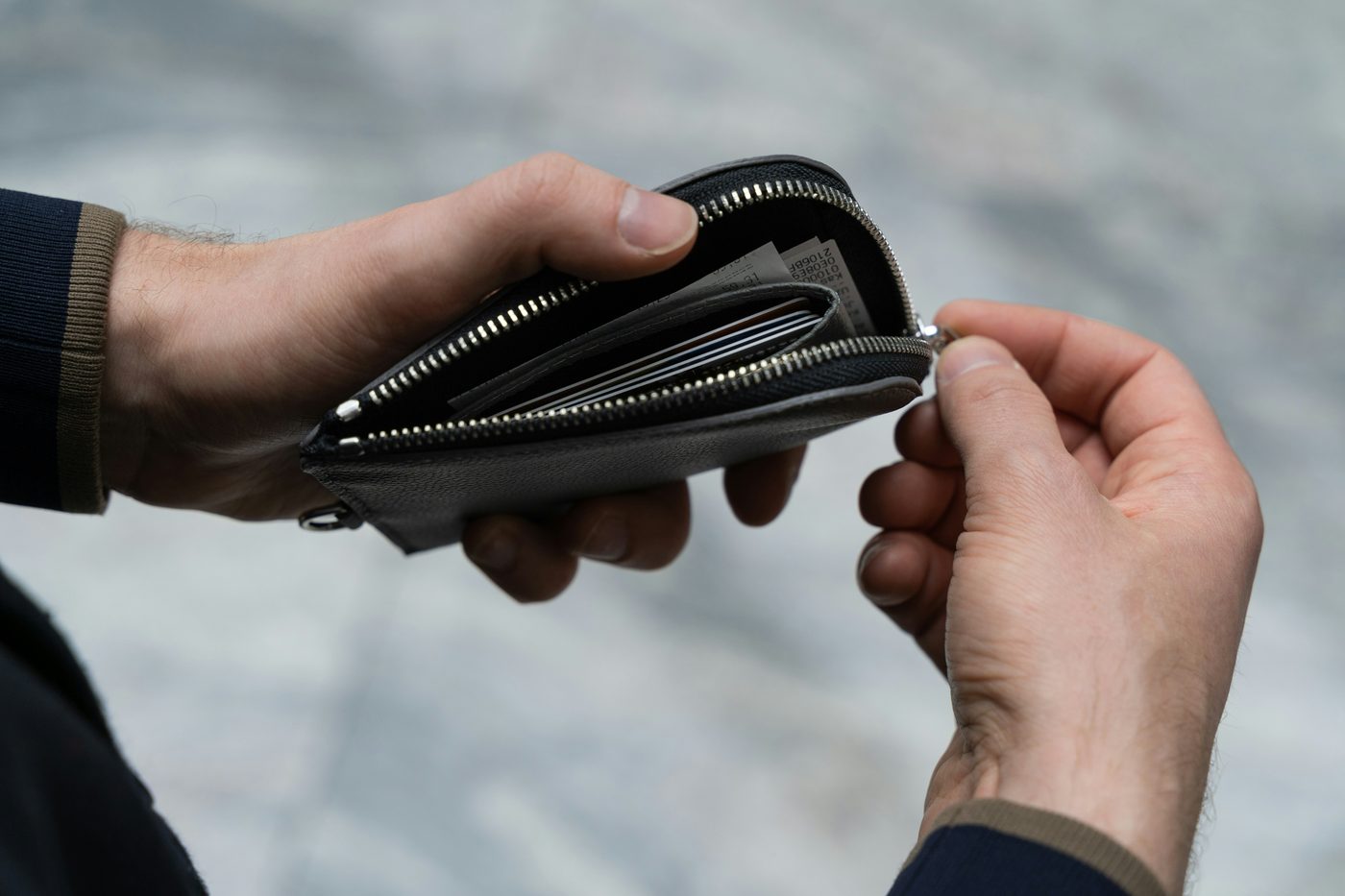 Hands opening a wallet containing cards, representing credit and financial standing
