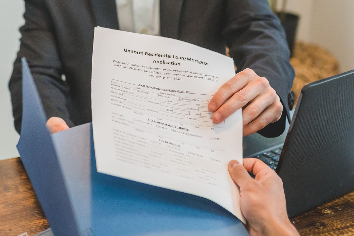 Loan officer handing over a completed loan application form, representing the funding process